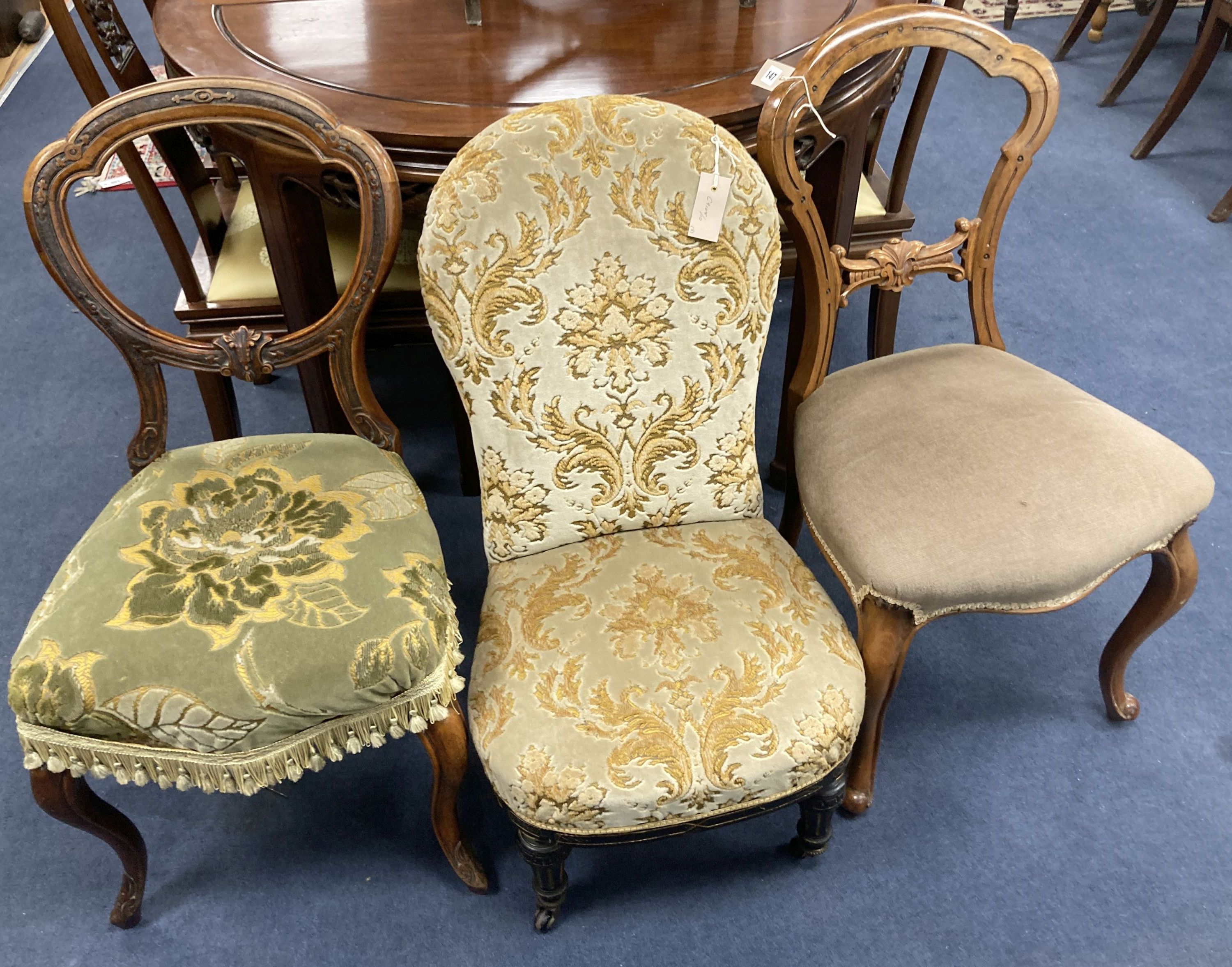 A Victorian ebonised and gilt upholstered nursing chair and pair of balloon back chairs